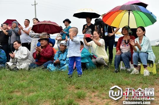 圖為牧民在雨中觀看烏蘭牧騎演出抬探∽咏恚　翟璐 攝